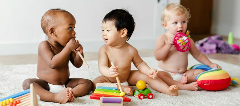 Three toddlers playing with toys