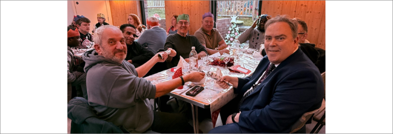 Mayor Perry sitting with volunteers at Christmas lunch