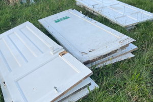 A pile of fly-tipped doors on a green