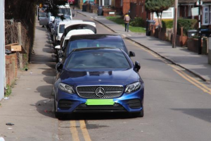 Cars parked on double yellow lines on a street