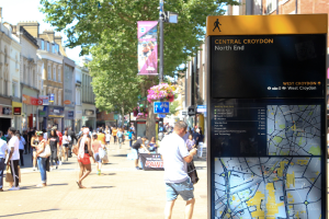 Shoppers in North End, with focus on wayfinding sign