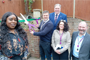 A group of people at a ribbon cutting for the opening of a children's centre