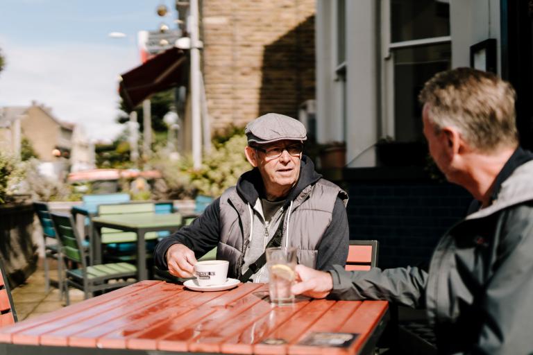 Two men drinking outside