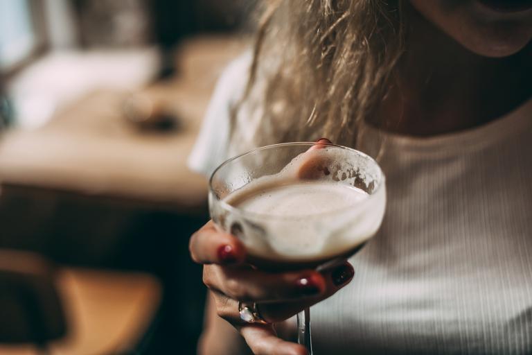 Woman holds glass of alcohol