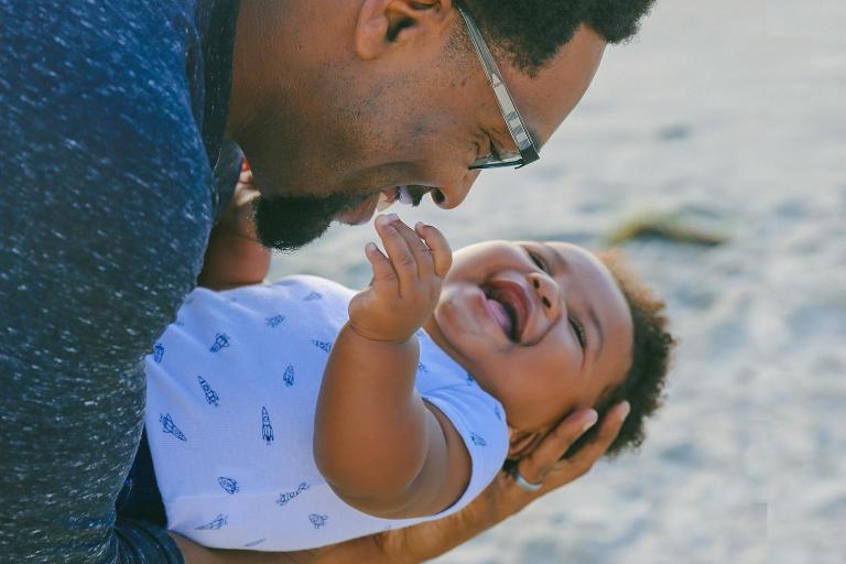 Father holding his baby close in his arms in a play area